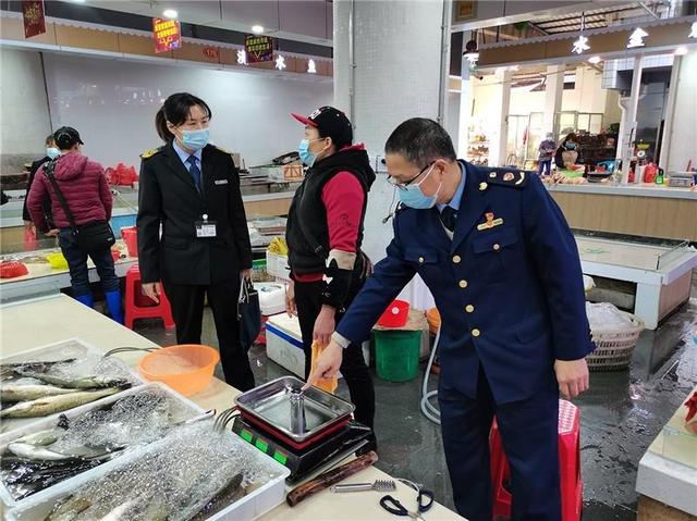 执法人员对农贸市场计量器具进行监督检查